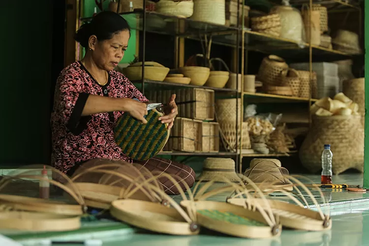 Pengrajin menyelesaikan anyaman tudung saji dari bambu