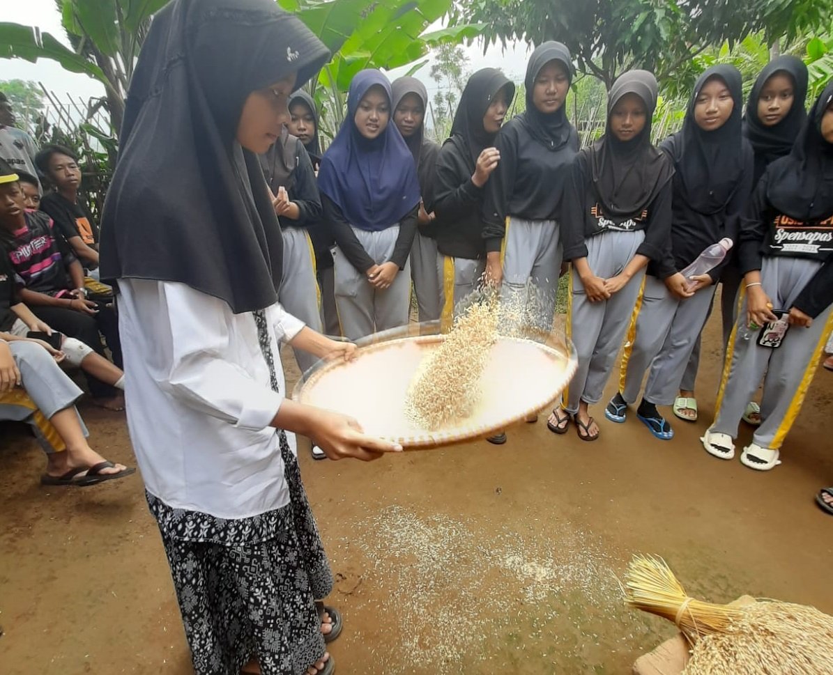 Kegiatan nampi beas bersama warga dan siswa